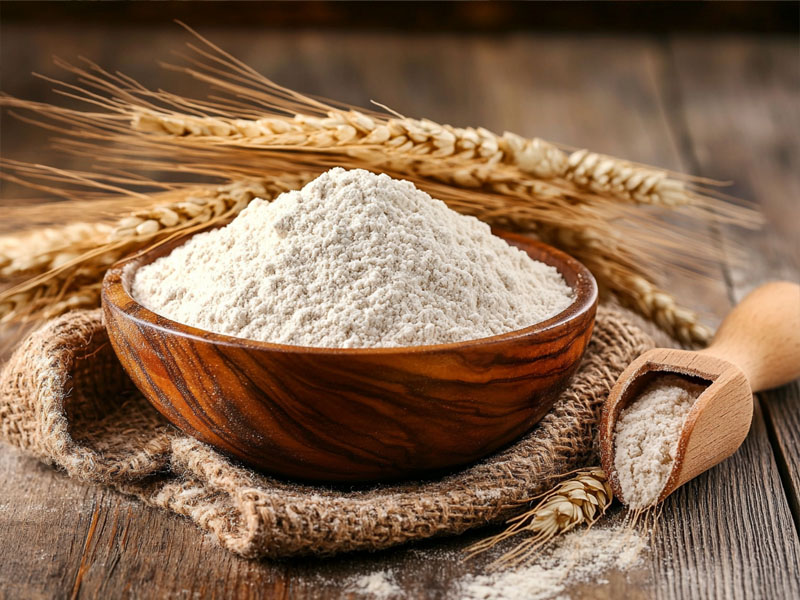 Fresh stone-ground whole wheat flour with wheat stalks